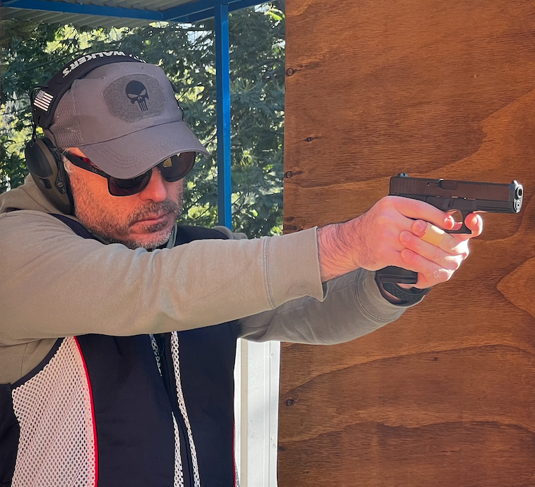 Instructor apuntando con pistola semiautomática en el polígono
